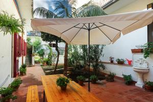 a wooden table with an umbrella in a courtyard at Sea Shell in Riposto