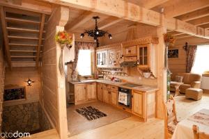 コシチェリスコにあるSmerkowy Dworekの木製キャビネット付きのログキャビン内のキッチン