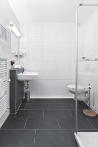 bagno bianco con lavandino e servizi igienici di Hotel Klinkner a Emmelshausen