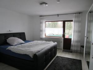 1 dormitorio con cama y ventana en Ferienwohnung Gipfelblick en Oberreute