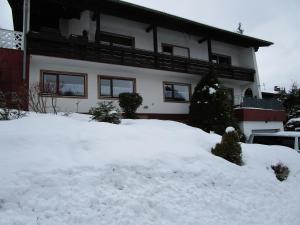 a house with a pile of snow in front of it at Ferienwohnung Gipfelblick in Oberreute