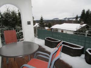 a table and chairs on a balcony covered in snow at Ferienwohnung Gipfelblick in Oberreute