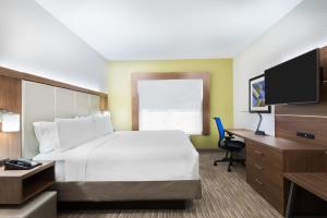 a hotel room with a bed and a desk and a tv at Holiday Inn Express & Suites - Columbus Airport East by IHG in Columbus