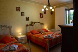 ガリポリにあるPROFUMO DI MARE B&Bのベッドルーム1室(オレンジ色の枕が備わるベッド2台付)
