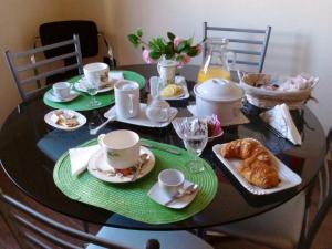 a dining room table with a table set with tea and croissants at B&B dal Cardinale in Ozieri