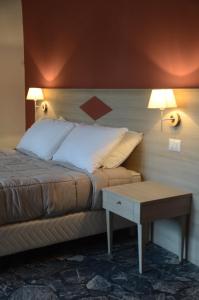 a bed in a room with two lamps and a table at Kaliè Rooms Guest House in Cagliari