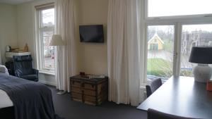 a bedroom with a bed and a table and a window at Room One-Twenty-One in Naarden