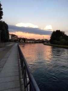 una vista de un río con la puesta de sol en el fondo en La Terrazza sul Naviglio B&B, en Bernate Ticino