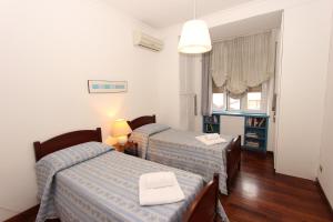 a bedroom with two beds and a table with a lamp at Pacinotti Flats in Rome