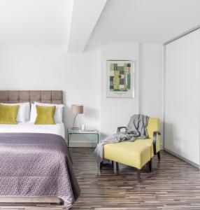 um quarto com uma cama e uma cadeira amarela em SACO Holborn – Lamb’s Conduit St em Londres