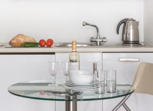 uma mesa de vidro com uma garrafa de vinho e copos em SACO Holborn – Lamb’s Conduit St em Londres