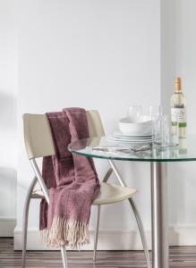 a glass table and a chair with a blanket on it at SACO Holborn – Lamb’s Conduit St in London