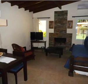 sala de estar con sofá y chimenea en Complejo Viva Zapata en Mar de las Pampas