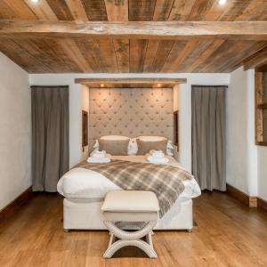 a bedroom with a large bed and a wooden ceiling at The Cow Dalbury in Dalbury Lees