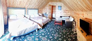 a bedroom with two beds and a fireplace at Sadyba Smotrytska Perlyna in Kamianets-Podilskyi