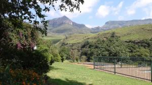 a fence with a view of mountains in the background at Ledges Retreat in Bergville