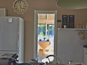 eine Küche mit einer Uhr an der Wand und einer offenen Tür in der Unterkunft La Terrazza sul Naviglio B&B in Bernate Ticino