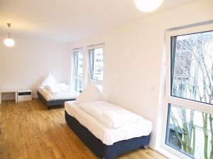 1 dormitorio con 2 camas y ventana en AVI City Apartments KingHouse en Düsseldorf
