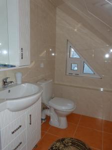 a bathroom with a white sink and a toilet at Sadyba Smotrytska Perlyna in Kamianets-Podilskyi +36 photos