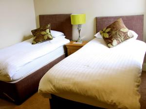 a hotel room with two beds and a lamp at The Arun View Inn in Littlehampton