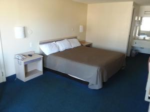 a hotel room with a bed and a small table at Knights Inn Burlington NC in Burlington