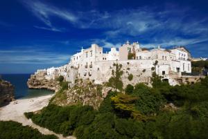 a castle on a cliff next to the ocean at Palazzo Maringelli in Polignano a Mare