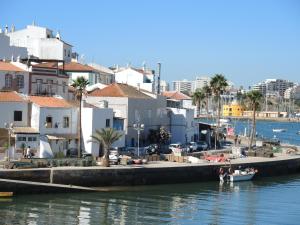 a boat is docked at a dock in a harbor at Casa do Gato in Ferragudo