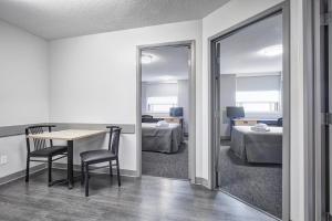 een kamer met een tafel en een slaapkamer met 2 bedden bij Residence & Conference Centre - Toronto in Toronto