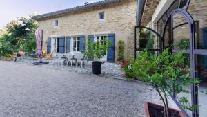 a house with a patio with tables and chairs at La Jourdane in Saint-Alexandre