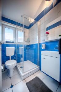 a blue and white bathroom with a toilet and a shower at Seafront Suites Maja in Vis