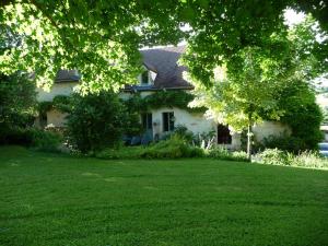a white house with a lawn in front of it at Le Pré Vert in Crugey
