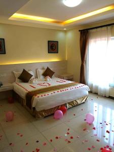 a bedroom with a bed with pink hearts on the floor at Nanjing Restaurant & Motel in Kampala
