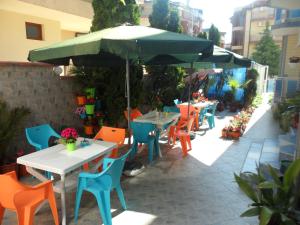 a patio with tables and chairs under an umbrella at Sianie Guest House in Ravda