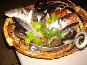 mit Fisch und anderen Lebensmitteln gefüllter Korb in der Unterkunft Hotel Perda Rubia in San Giovanni Suergiu