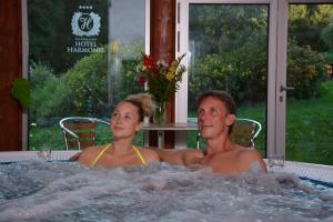 a man and woman in a jacuzzi in a hot tub at Spa & Wellness Hotel Harmonie in Mariánské Lázně