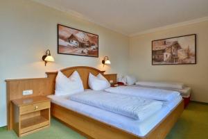 a bedroom with two beds with white pillows at Gasthof und Hotel Rieder GmbH in Jenbach