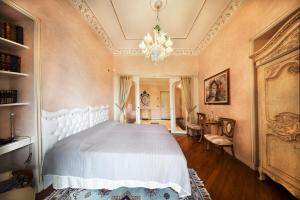 a bedroom with a white bed and a chandelier at Villa Castiglioni Luxury Apartment in Laglio