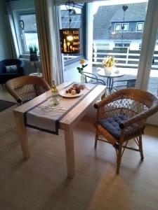 einem Holztisch mit zwei Stühlen und einem Tisch mit Essen darauf in der Unterkunft Ferienappartement Potthoff 1 in Altenau