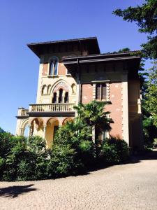 um grande edifício de tijolos com uma varanda em Villa Castiglioni Luxury Apartment em Laglio