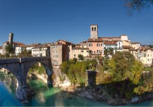un pont sur une rivière avec une ville en arrière-plan dans l'établissement Il Gattopardo, à Cividale del Friuli