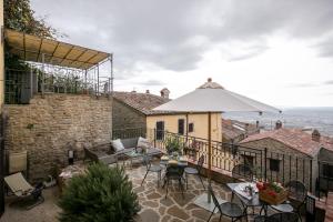 a patio with tables and chairs and an umbrella at Belvedere in Cortona