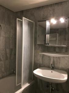 Un baño con lavabo y ducha y un lavabo. en Stadt Apartment, en Günzburg 71 fotos más