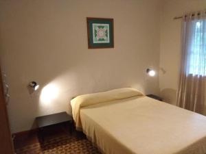 een slaapkamer met een wit bed en een raam bij El Limon in San Marcos Sierras