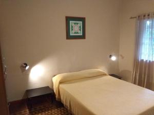 een slaapkamer met een bed en een schilderij aan de muur bij El Limon in San Marcos Sierras