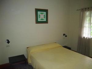 een slaapkamer met een bed en een schilderij aan de muur bij El Limon in San Marcos Sierras