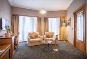 ein Wohnzimmer mit einem Sofa und einem Tisch in der Unterkunft Hotel Colosseo Tirana in Tirana