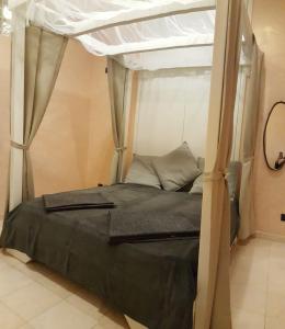 ein Schlafzimmer mit einem Himmelbett in der Unterkunft Appartamento Via Matteotti in Sanremo