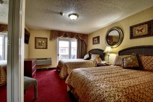 a hotel room with two beds and a mirror at Roosevelt Inn & Suites Saratoga Springs in Saratoga Springs +93 photos