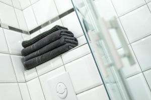 コルマールにあるSplendide Studio Centre Colmarのバスルームの棚に黒いタオルを積み重ねた