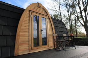 a dome house with a glass door on a deck at Trekkershut in Jubbega-Schurega